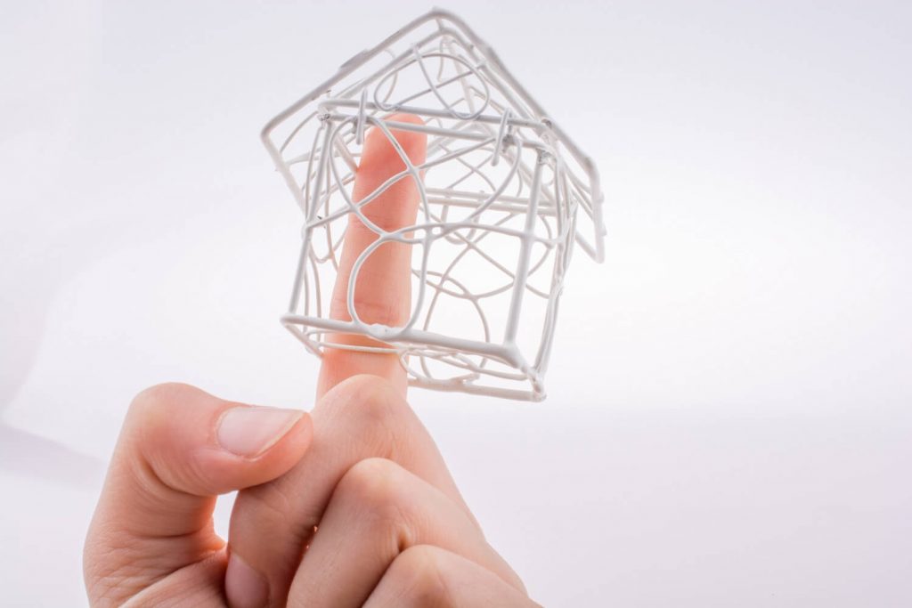Figurine of a house made of wire on a man's finger