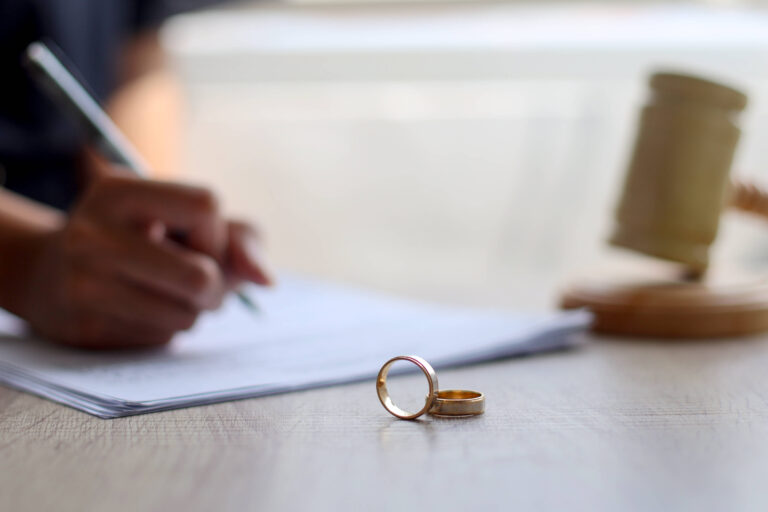 woman signing documents for contested divorce
